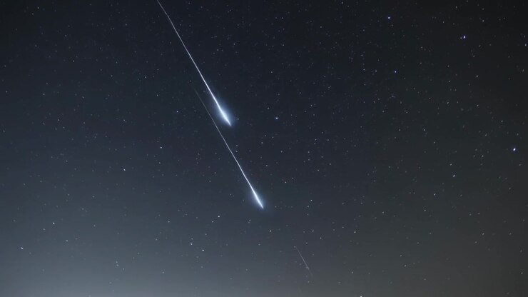 Appearing bright streak, meteor entering atmosphere and fragmenting over star field, leaving trail