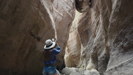 una mujer explorando un estrecho cañón.