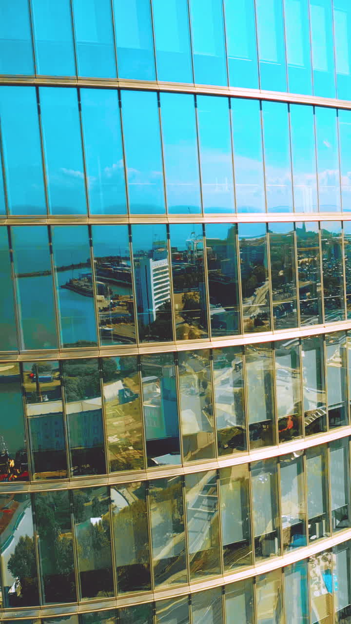 Reflexos da Cidade e do Mar em Fachada Moderna de Edifício de Vidro