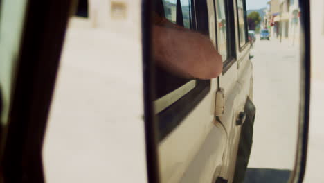 close up of sideview mirror, person waiting in car on street, mallorca