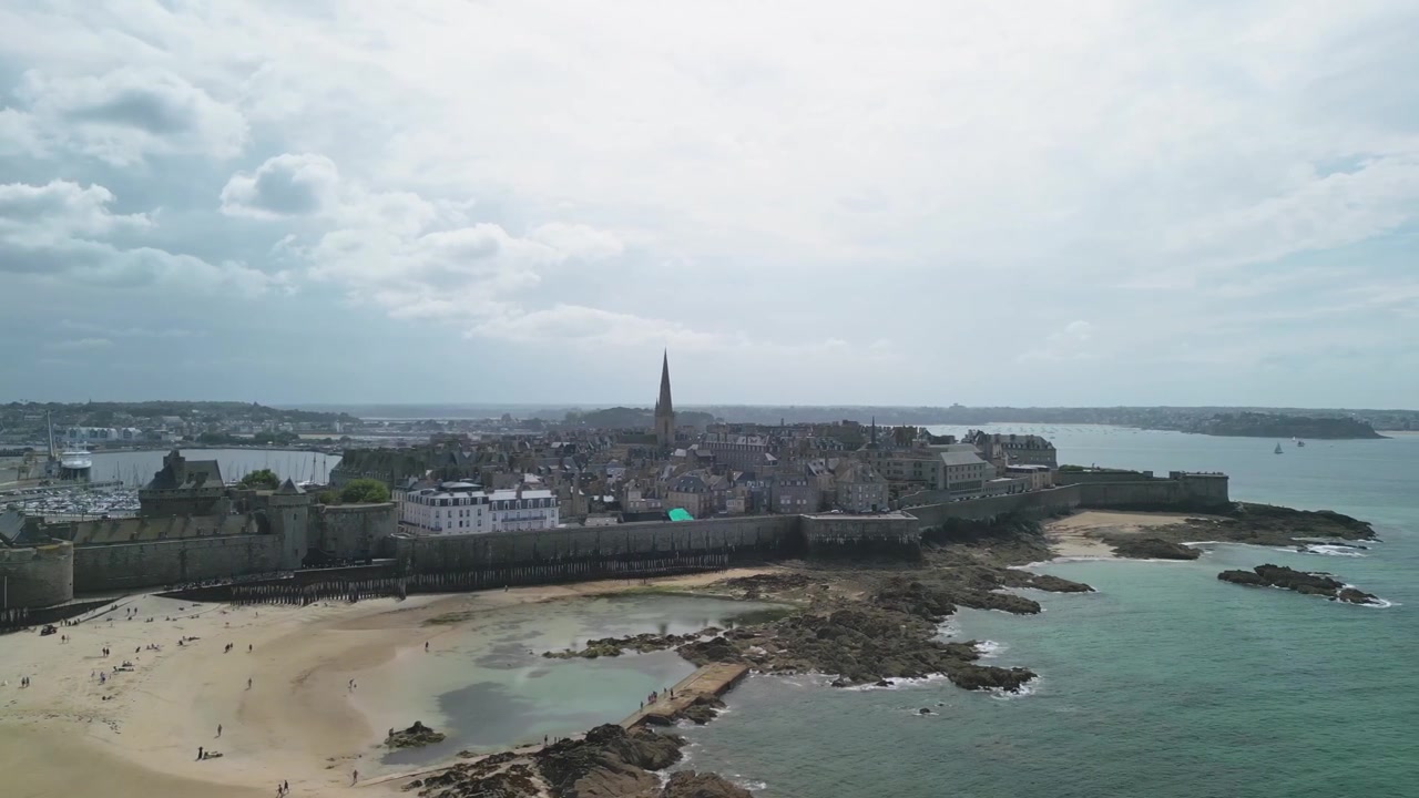 Mouvement de drone par une journée ensoleillée : remparts de Saint-Malo, vieille ville et plage