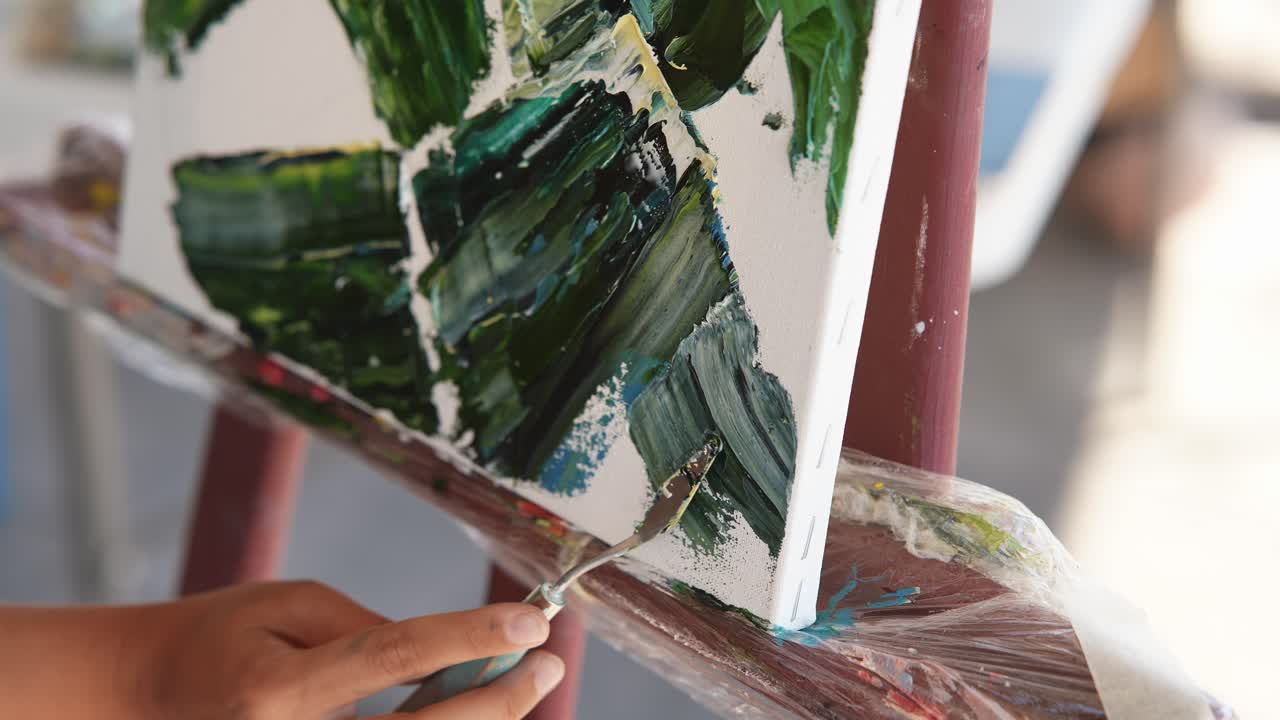 팔레트 칼을 사용하여 추상적인 작품을 그리는 예술가의 클로즈업