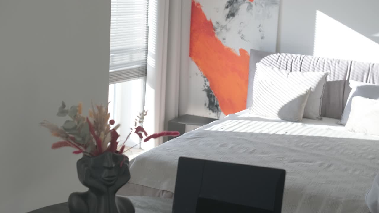 diseño y decoración de interiores de dormitorios modernos con sábanas blancas y grises, silla blanca, cabecera de luz nocturna.