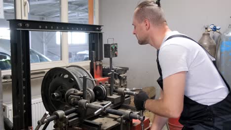 man repairing car wheel rim in a workshop