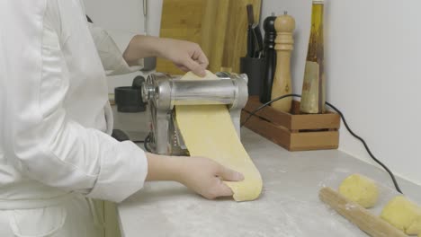 passing pasta dough through cooking press machine. closeup