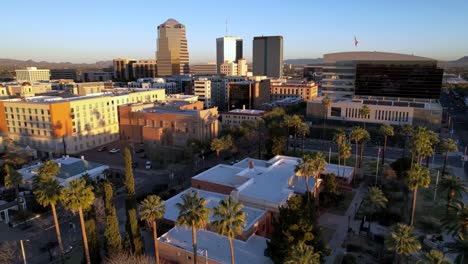 Extracción-Aérea-Al-Amanecer-Desde-El-Horizonte-De-Tucson,-Arizona,-Sobre-Las-Palmeras