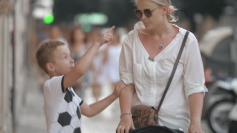 Family-walk-in-the-city-Mum-with-baby-daughter-in-stroller-and-elder-son