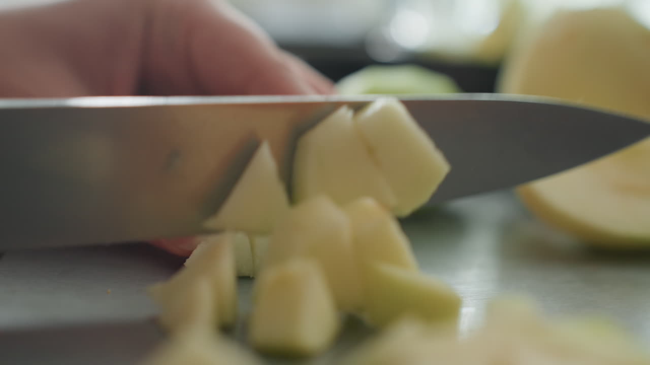 Diced fruit arranged by hands. Close up of hands preparing fruit for dessert presentation. Detailed view of hands carefully placing diced fruits on plate in natural kitchen lighting