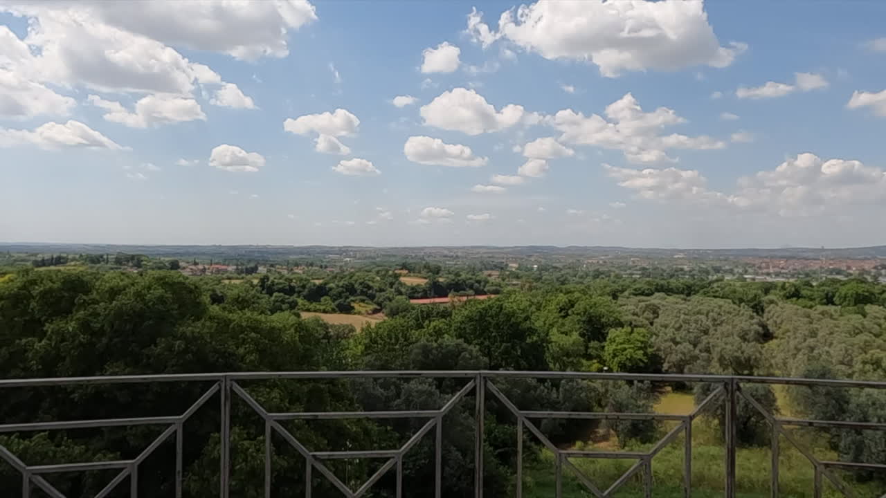 Impresionante vista panorámica desde una terraza histórica en Villa Adriana, cerca de Roma, Italia. Un exuberante paisaje verde se extiende bajo un dramático cielo nublado en verano
