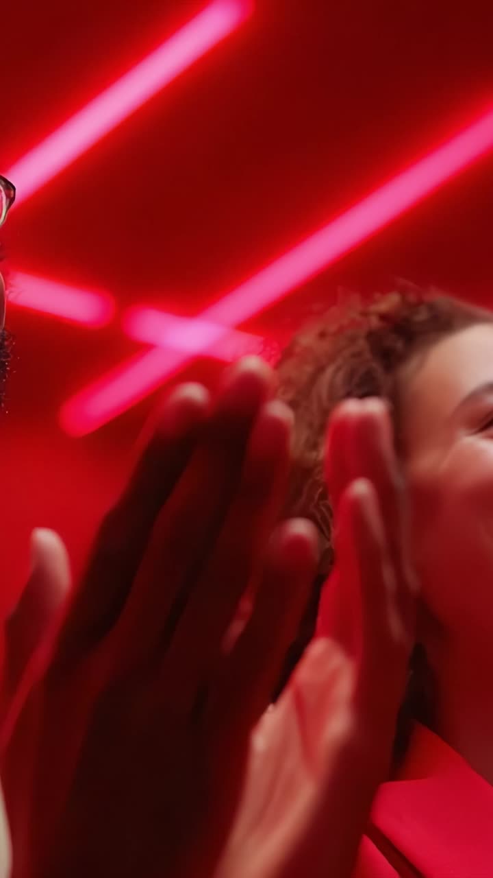Momentos de celebración capturados en una vibrante luz roja: alegría, conexión y entusiasmo expresados a través de emociones compartidas y gestos animados en un entorno dinámico