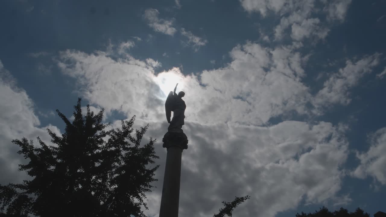 lapso de tiempo del sol-luna pasando detrás de la estatua del cementerio en el pilar