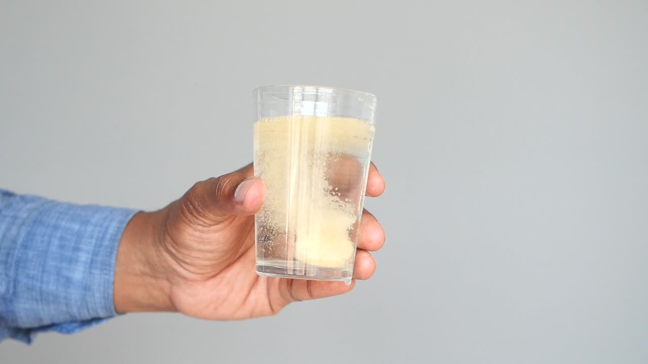 용해 태블릿 을 가진 물 한 잔 을 들고 있는 사람