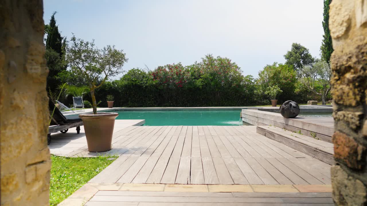 dolly lentamente sparato attraverso un cancello di pietra che rivela una piscina tropicale privata