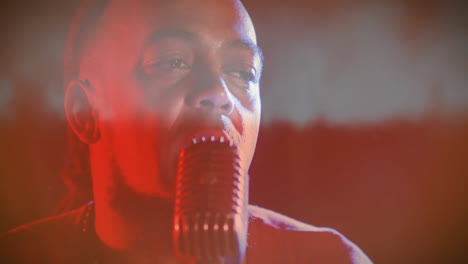 man singing into retro microphone on music stage amid red haze, overlaying animated wave charts