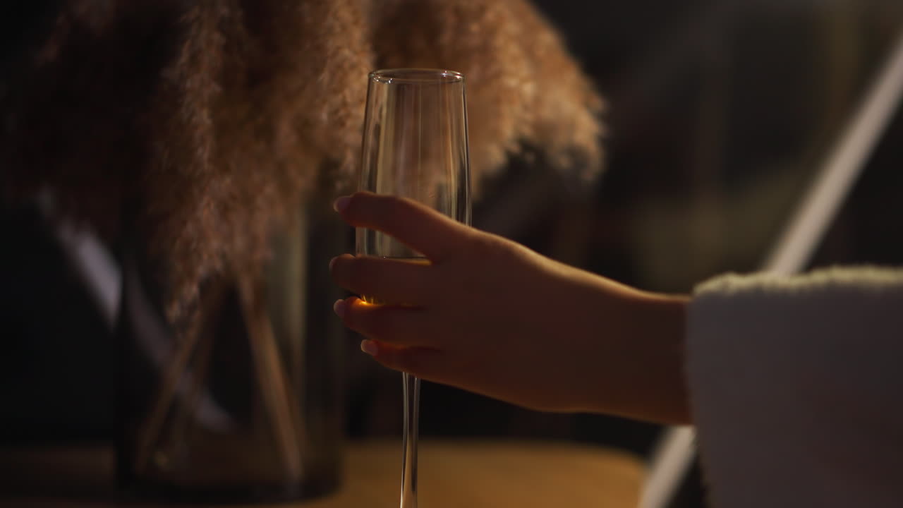 여성 손은 장식 요소와 함께 나무 테이블에 반 빈 페인 컵을 놓습니다. 편안하고 혼자 알코올 음료를 마시는 개념 느린 모션