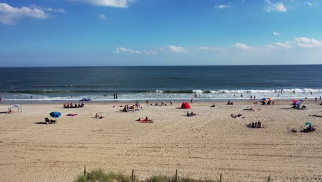 A-drone-view-of-people-relaxing-on-the-beach-on-a-sunny-day