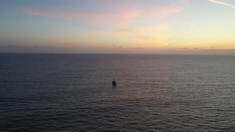 barco navegando por el océano en calma al atardecer