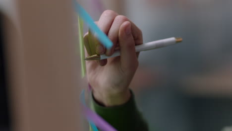 close up business woman hand writing on colorful sticky notes paper brainstorming creative ideas using multicolored post it planning ahead organized management strategy in office