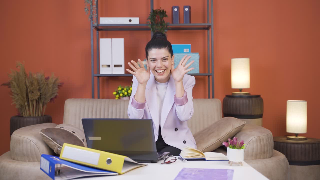 Home office worker young woman making cute gesture at camera.
