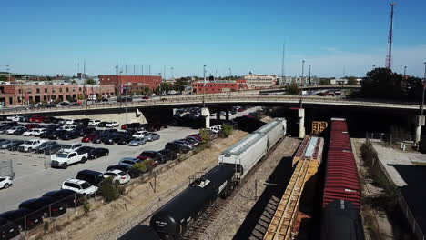 drone captures the video of the freight train or cargo train carrying multiple coaches and numerous car can be seen parked on the side and overhead bridge