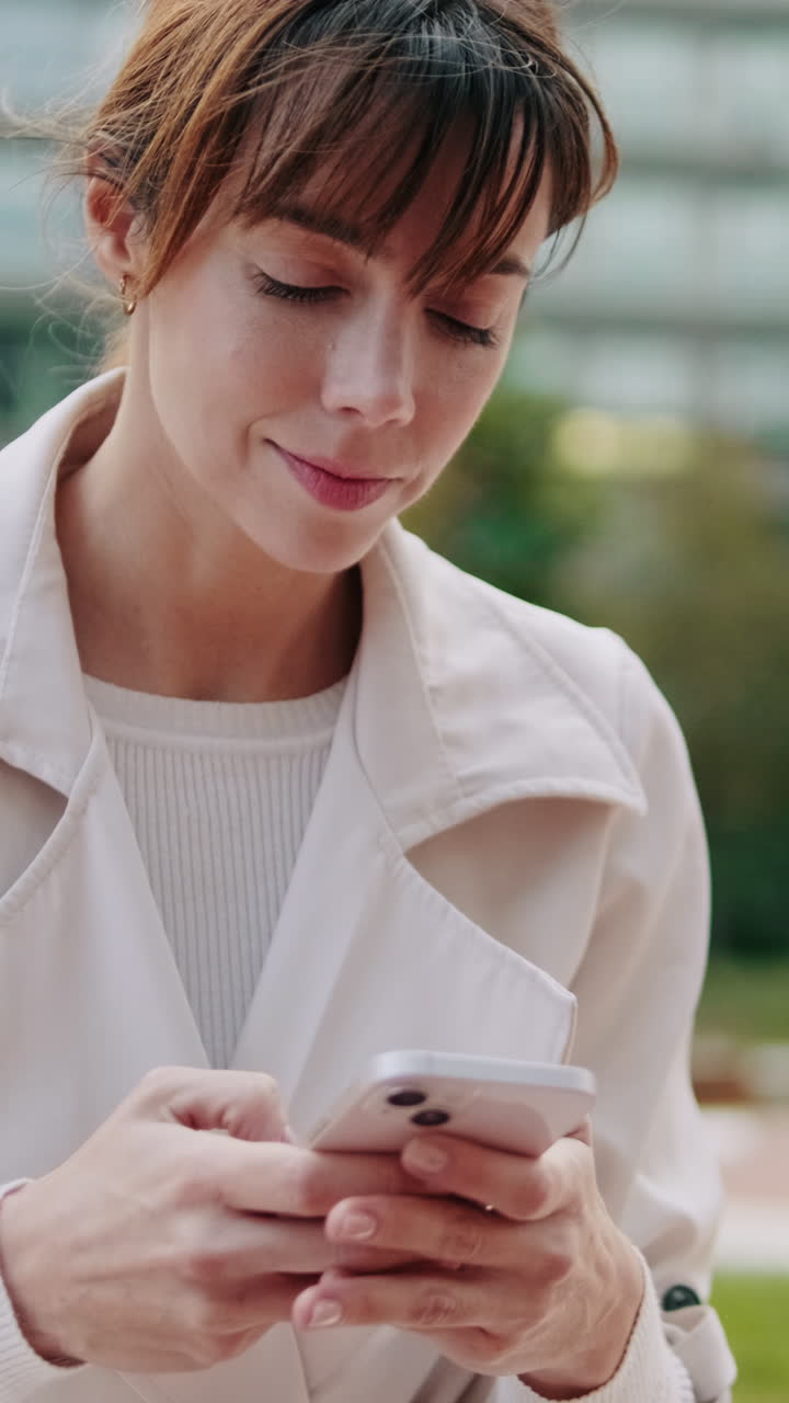 Giovane donna che manda messaggi sullo smartphone all'aperto
