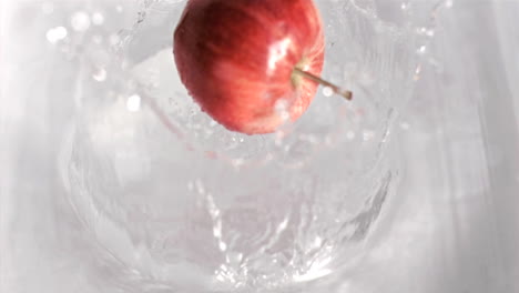 manzana cayendo en el agua en súper cámara lenta