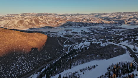 park city utah aerial v21 cinematic flyover capturing beautiful snowy mountainscape and pristine winter landscape with frozen jordanelle reservoir at sunset - shot with mavic 3 cine - february 2022