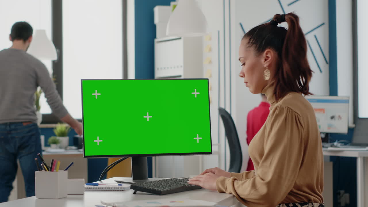 Employee working with green screen on computer