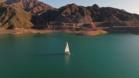 Rotierende-Aufnahme-Eines-Kleinen-Segelboots,-Das-Vor-Der-Küste-Von-Mendoza,-Argentinien,-Vor-Anker-Liegt