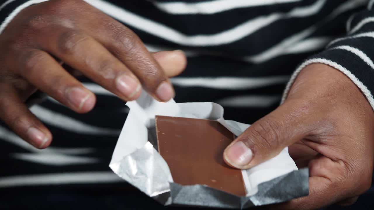 persona desempaquetando una barra de chocolate