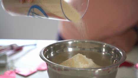 Close-up-of-pouring-sugar-in-bowl-making-a-special-valentine's-day-cake-vegan-chocolate-cake-eggless-plant-based-dairy-free