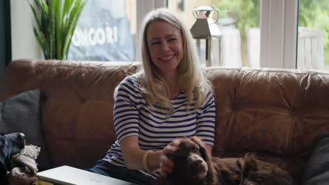 woman and dog relaxing on couch at home