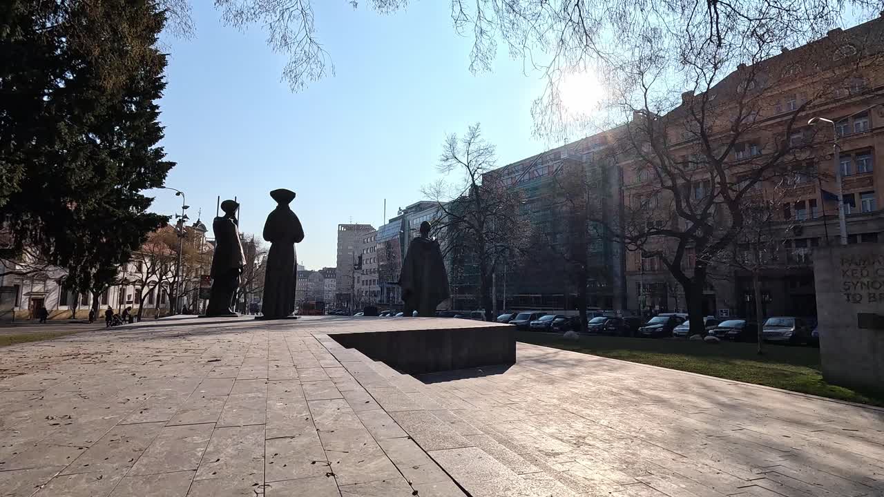 Bronze statues of traditional Slovak figures in Námestie SNP square under bright sunlight in Bratislava, Slovakia