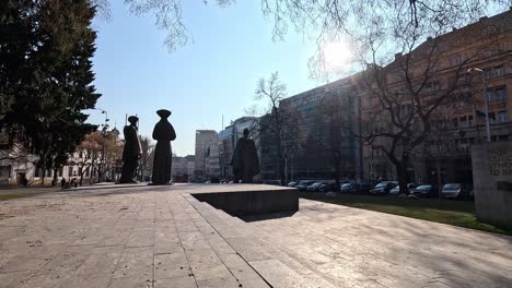 bronze statues of traditional slovak figures in námestie snp square under bright sunlight in bratislava, slovakia