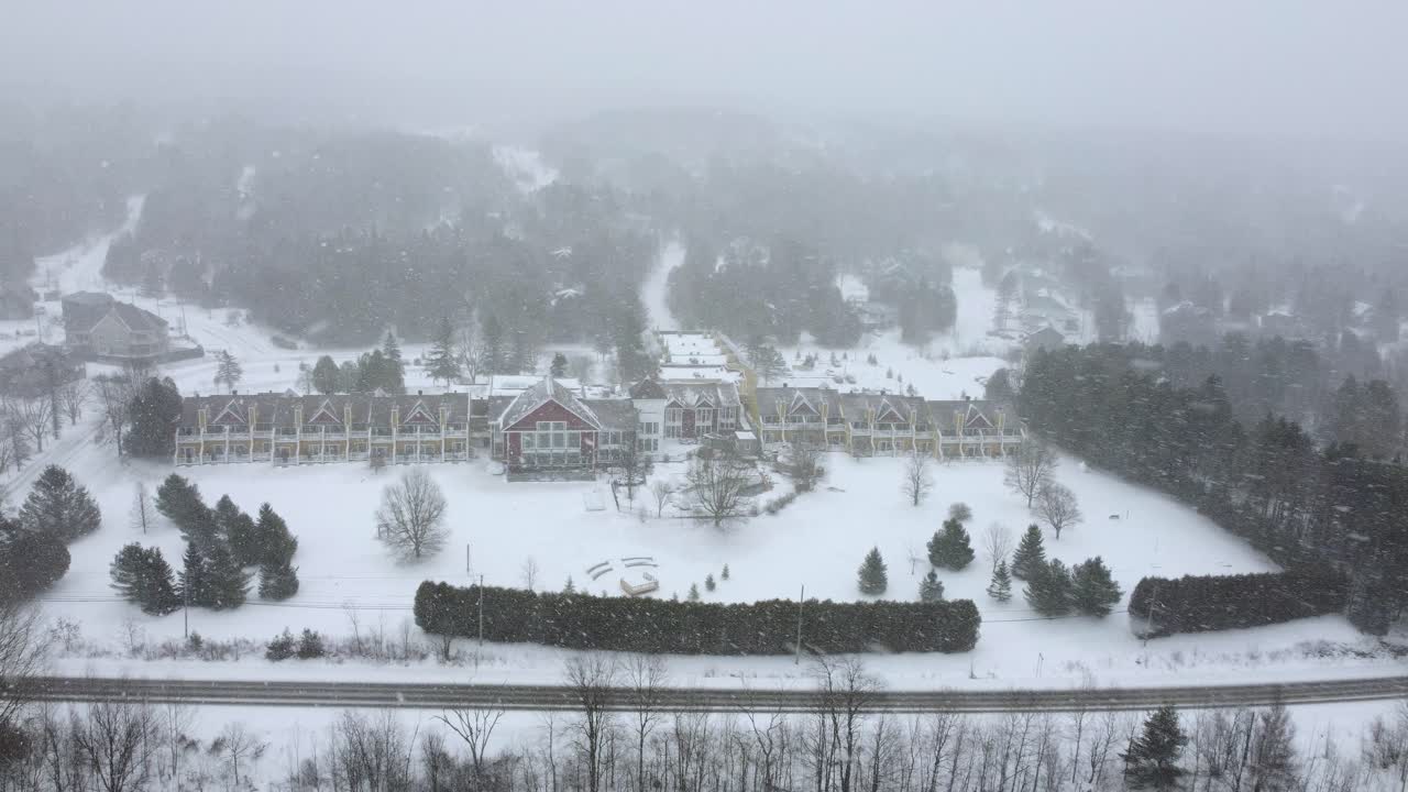 Mansion in Orford, Quebec, Canada during a winter storm with snow covered grounds. slow shot