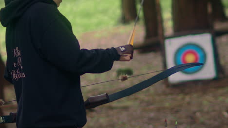 archery woman pulls and shoots arrow super slow motion back shot