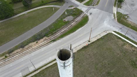 drone tilting over an old crumbling smokestack in an industrial park