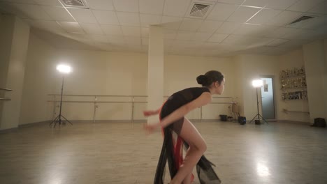 un grupo de jóvenes estudiantes de ballet con ropa de baile negra practicando posiciones en un amplio estudio de ballet con pisos de madera y barras montadas en la pared. expresiones enfocadas y movimientos sincronizados.