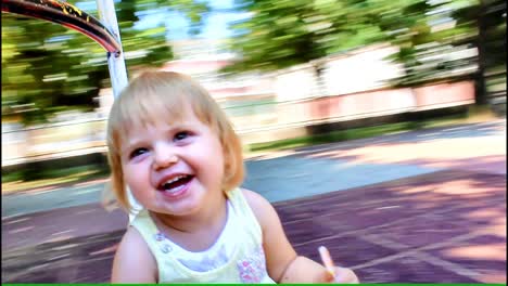 adorable toddler girl smiling and laughing, enjoying ride on the roundabout