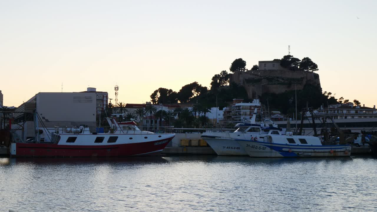 Porto peschereccio e castello di Denia, Spagna, al tramonto.