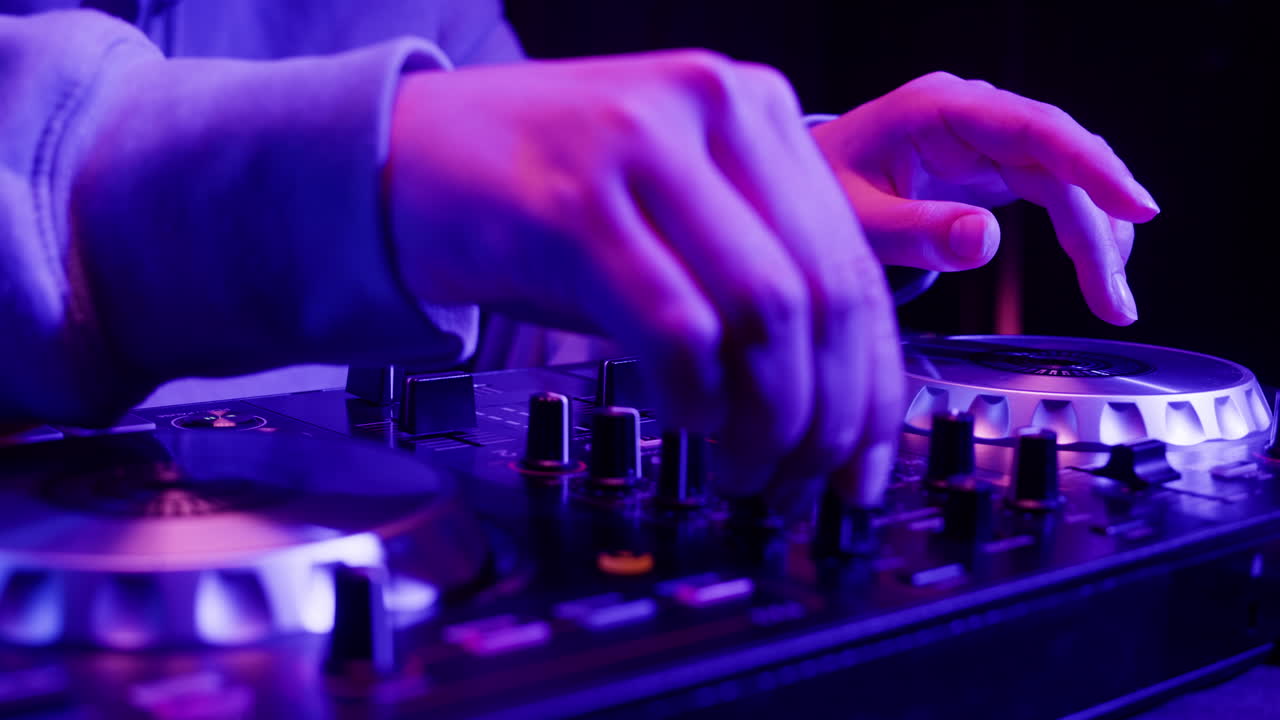 DJ with headphones and sunglasses playing music on festival in night club. Techno musician performing at nightclub for concert crowd of people, city bar.