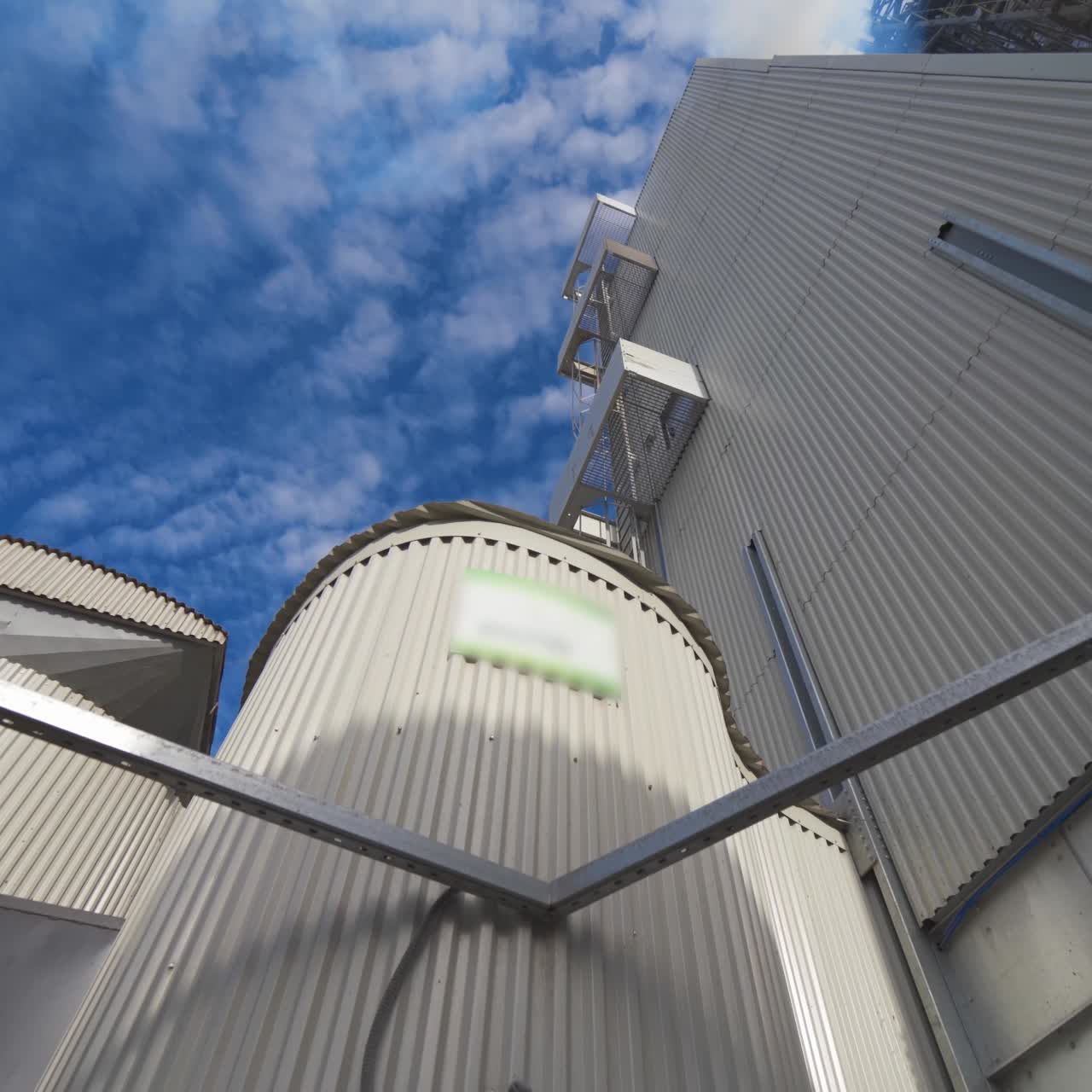 Metal construction of industrial plant. Industrial equipment of a modern agricultural complex for storing and processing grains against blue sky
