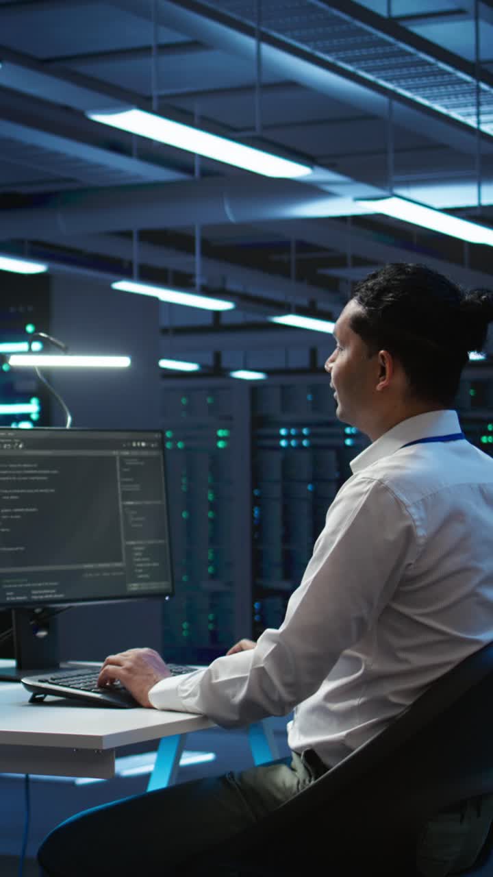 IT Professional Coding on Computer in Dark Server Room