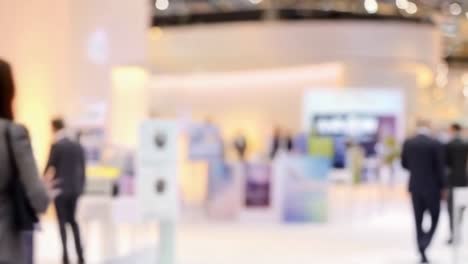 blurred business professionals walking at a modern conference or exhibition