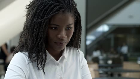 cheerful beautiful young woman with dreadlocks looking down