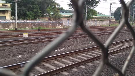 el punto de vista de los pasajeros desde una ventana de un tren local asiático, las vías férreas en movimiento entrecruzadas y los trenes que pasan dan la sensación de que alguien viaja en un tren y mira hacia afuera