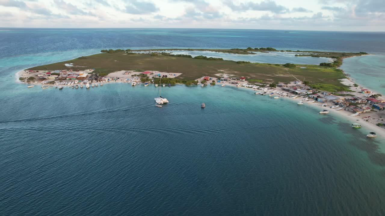 A coastal island with turquoise water and boats, mood: serene travel, aerial view