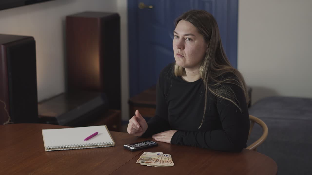 Tre donne leggono cattive notizie finanziarie su uno smartphone e reagiscono con preoccupazione durante una conversazione domestica sul denaro
