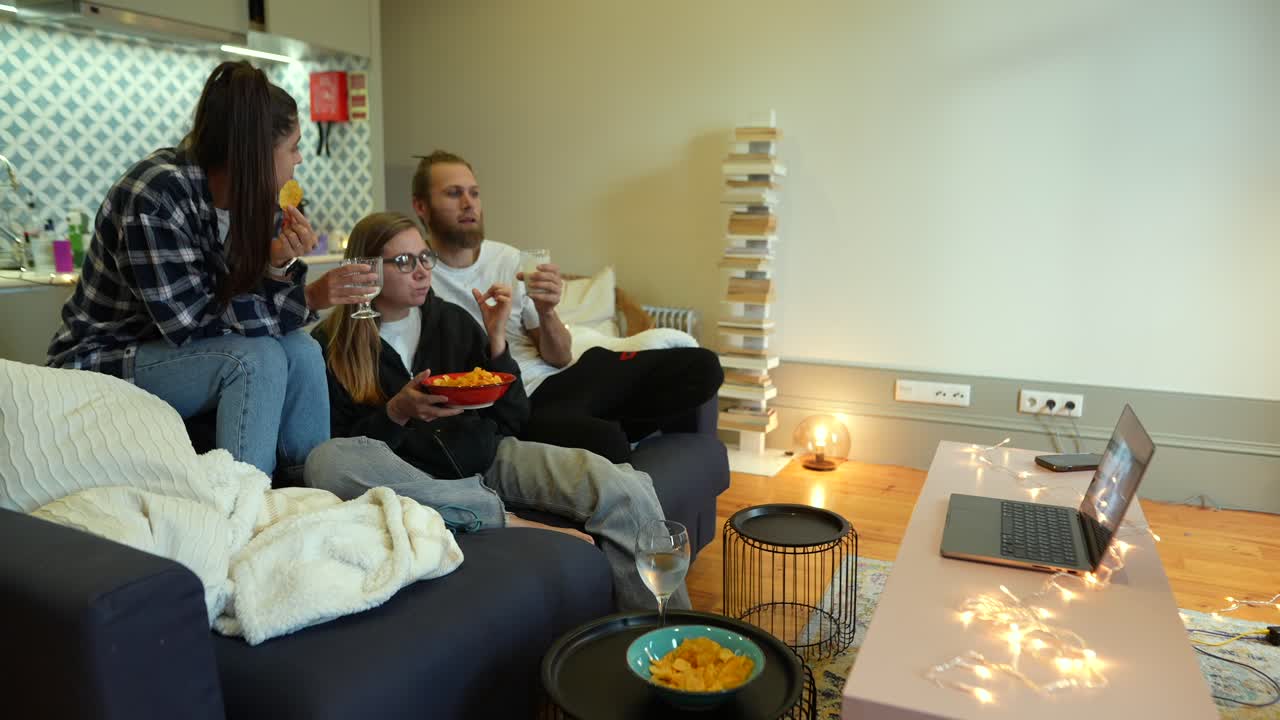 친구들이 집에서 영화를 보고 있습니다.