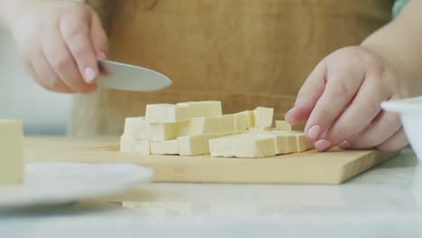 woman preparing cheese for cooking meal